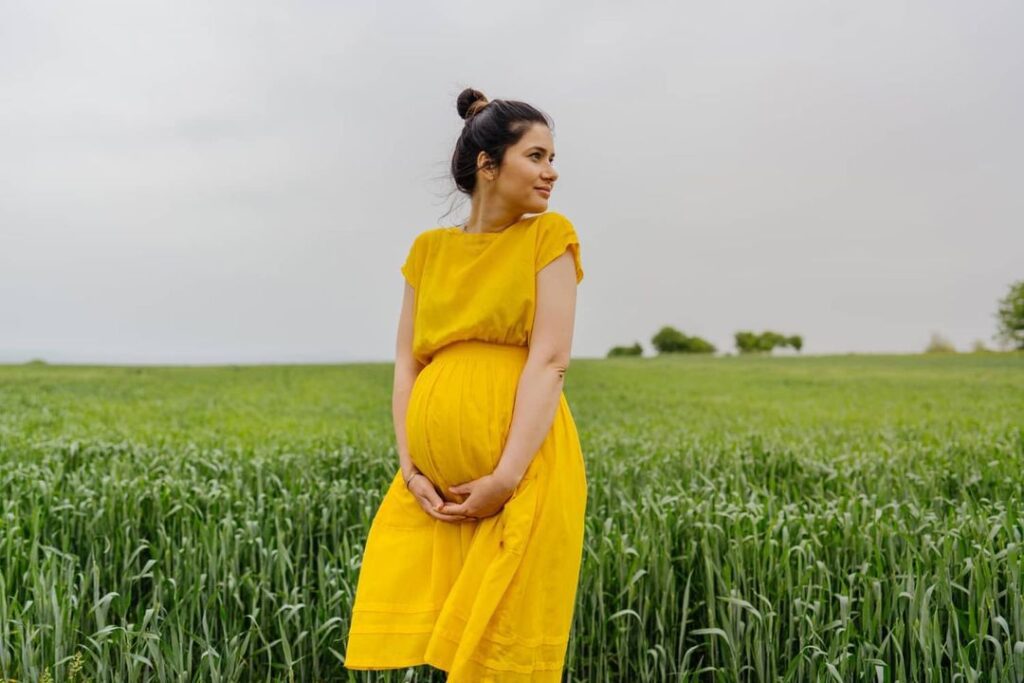 pregnant mother in green field