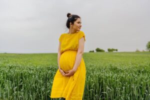 pregnant mother in green field