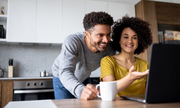 Couple at home making a reservation online using their laptop