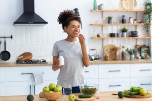 woman in kitchen taking her vitamins