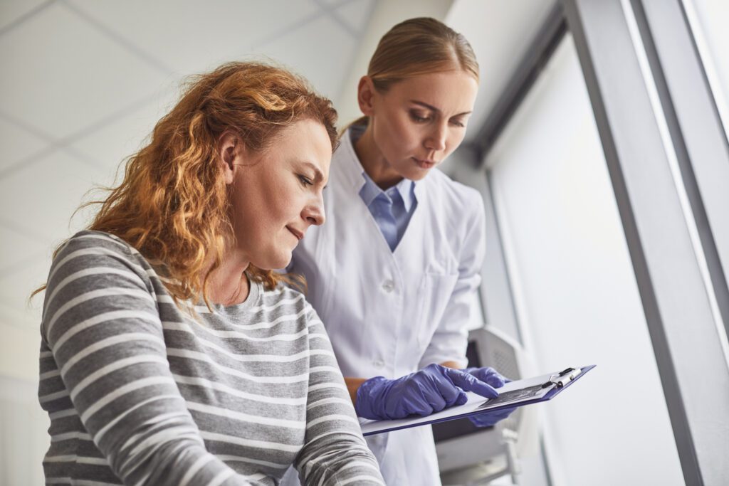 Doctor showing ultrasound baby picture to future mother