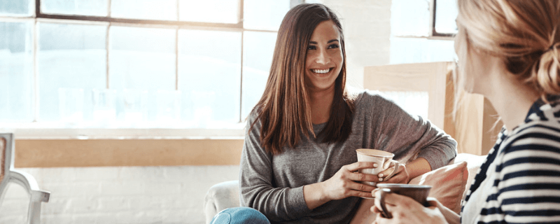 smiling woman speaking with another woman