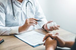 Doctor or physician recommend pills medical prescription to male Patient