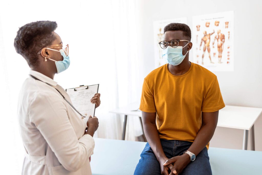 photo of patient speaking with a doctor in a medical examination room