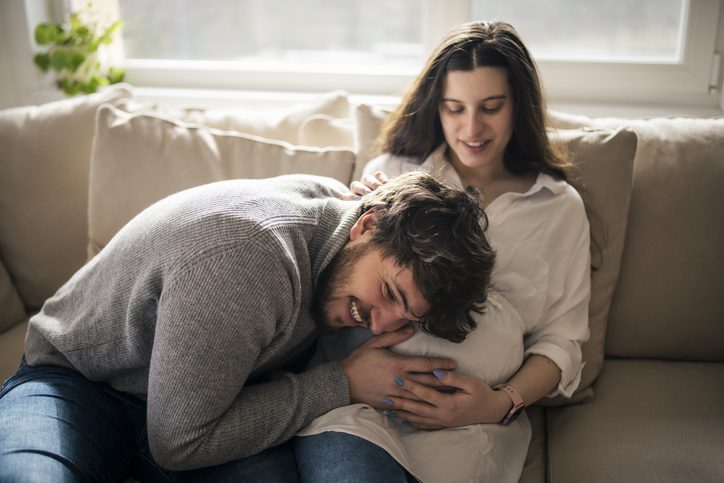 photo of a father with his head up against a pregnant mother's belly listening for his baby