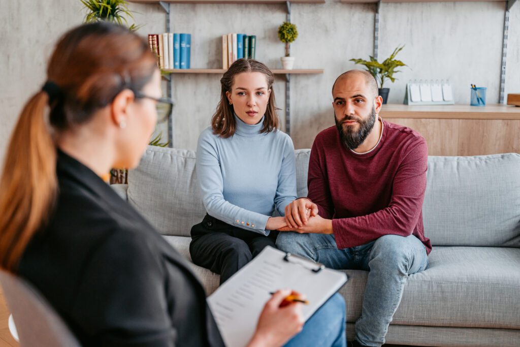 Husband and wife talking with physician about IUI vs IVF fertility treatments