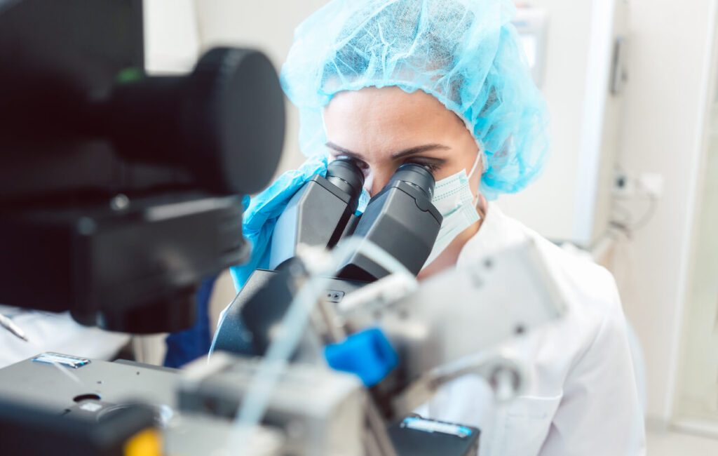 fertility doctor looking at a sample under a microscope