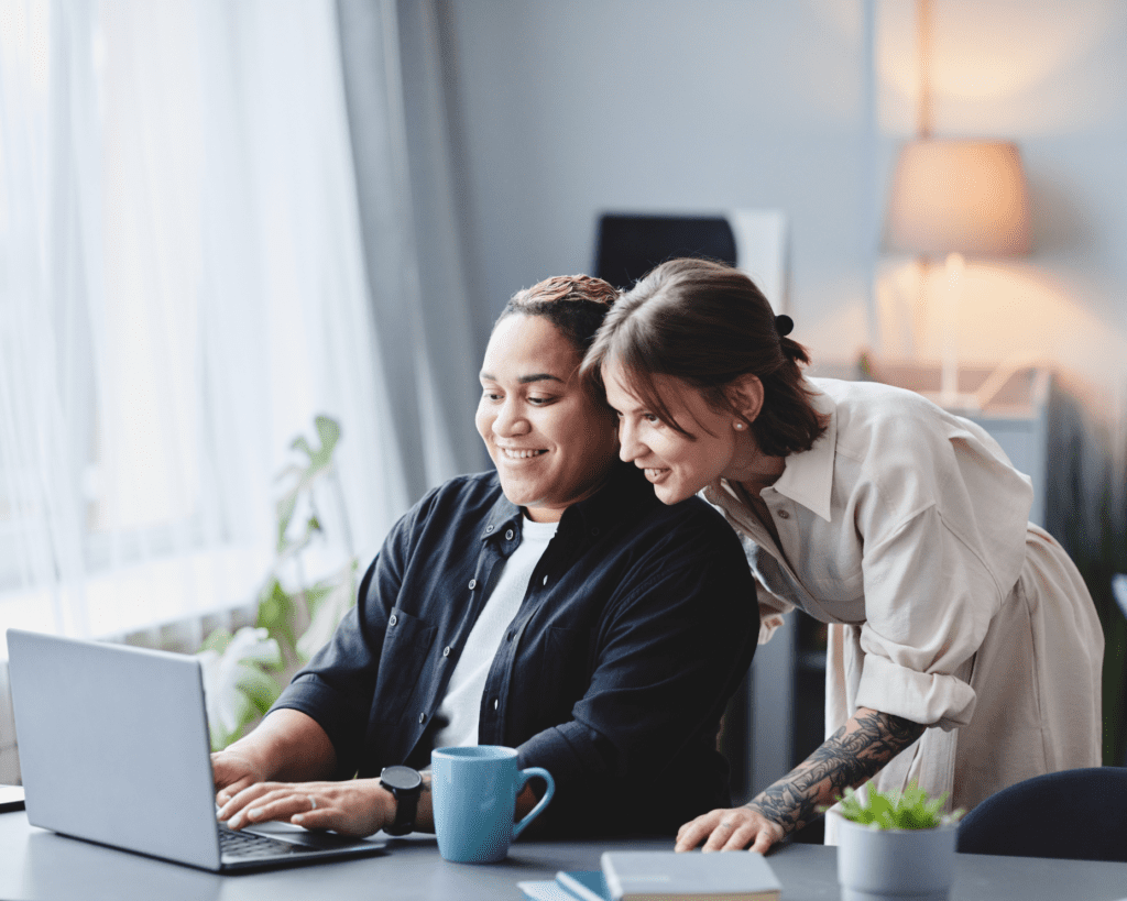 A happy couple shares a moment while looking at a laptop.
