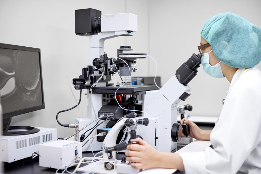 Laboratory technician performing in vitro fertilization of human egg