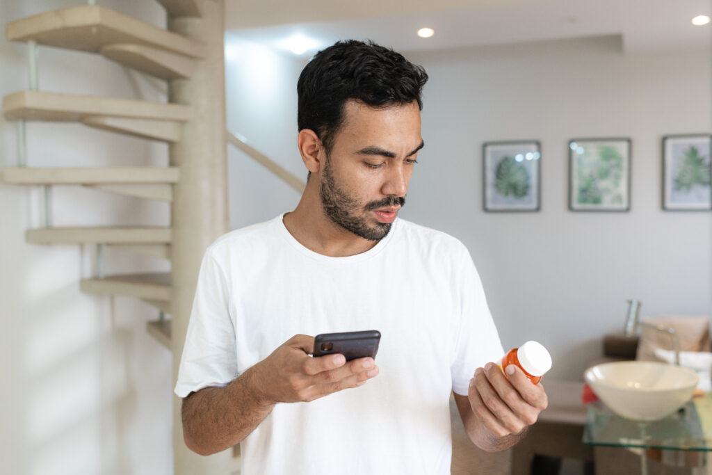 Young adult checking medication usage with cell phone