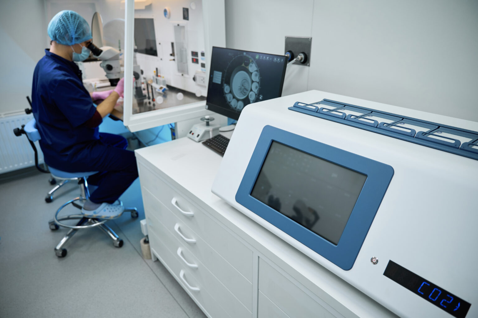 Embryologist monitors equipment during cryopreservation process in clinical lab