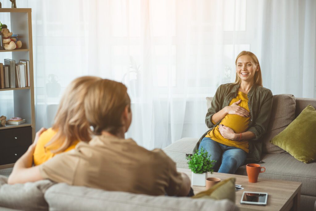 Cheerful surrogate expectant mother meeting married couple