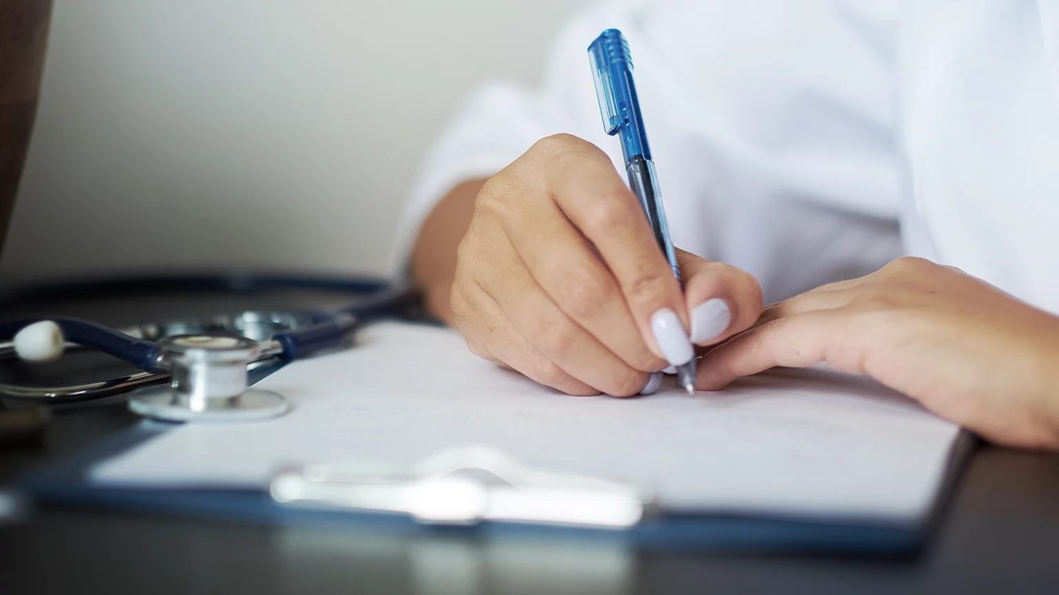 Doctor writing out requirements