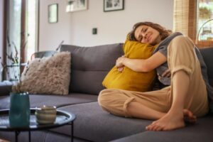 Female on Couch Hugging a Pillow Smiling