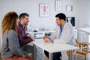 Young married couple consults with a doctor in the doctor’s office